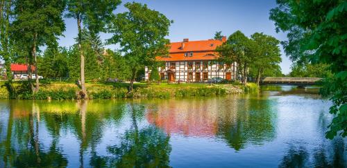 达尔沃沃格斯西尼匝姆科威宾馆的一座带橙色屋顶的建筑,毗邻湖泊