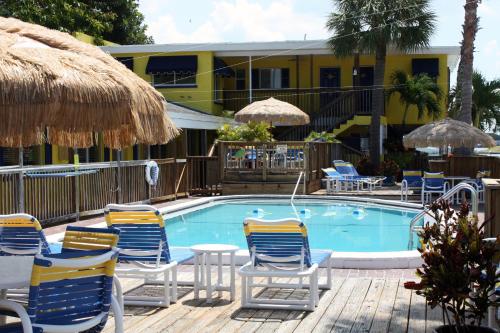 克利尔沃特赤脚湾度假汽车旅馆的一个带椅子和遮阳伞的游泳池