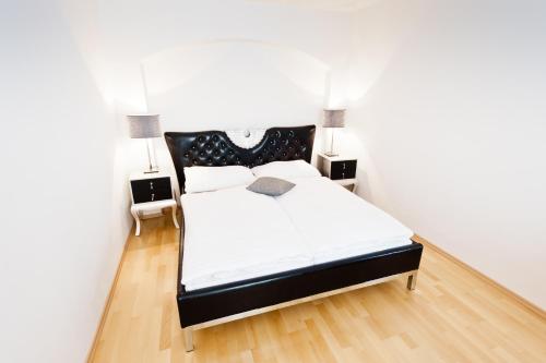 维也纳VOX设计酒店的一间卧室配有一张黑白床和两盏灯。
