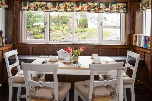 克里安拉利Glenbruar House的一间带桌椅和窗户的用餐室