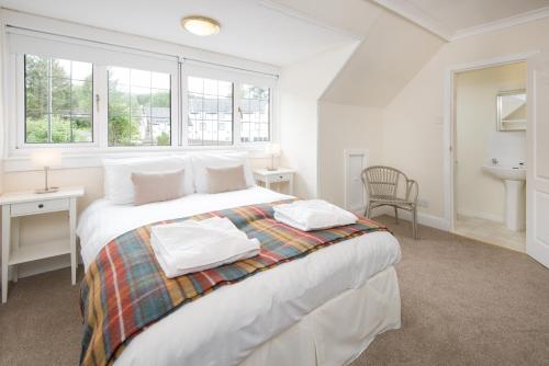克里安拉利Glenbruar House的白色卧室设有床、书桌和窗户