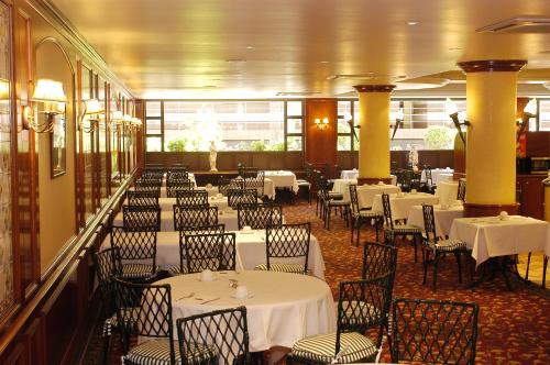 安道尔城安道​​尔宫酒店的一间设有白色桌椅的用餐室