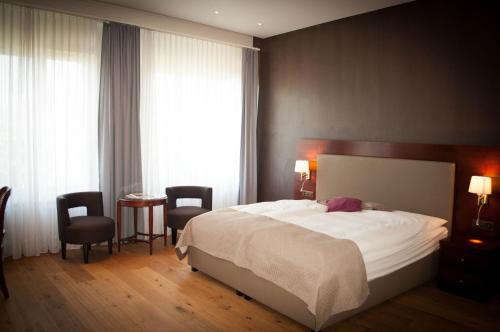 韦吉斯美岸韦吉斯罗曼蒂克酒店 - 美岸系列的一间卧室配有一张床、两把椅子和一张桌子