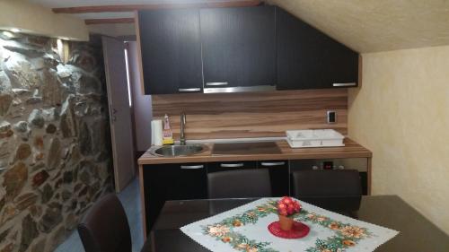 ResnikApartment Borovnica Rogla的小厨房,配有桌子,上面摆放着插花