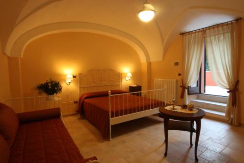 卡萨拉诺B&B Ippocastano的一间卧室配有一张床、一张沙发和一张桌子