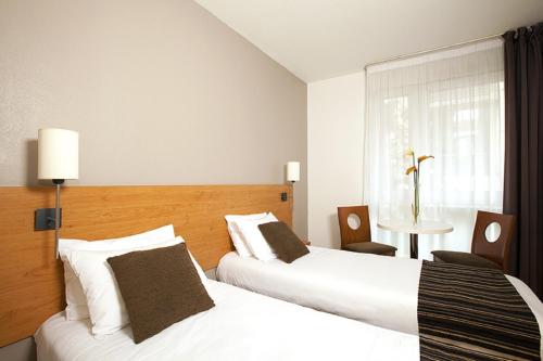 塞纳河畔伊夫里塞祖尔阿菲尔巴黎伊芙利酒店的酒店客房设有两张床和窗户。