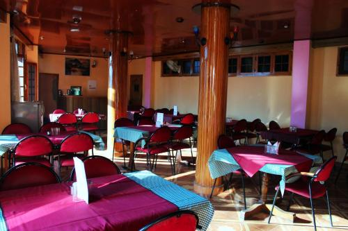 库尔卢Hotel Aroma Classic的用餐室配有桌椅和粉红色的桌子