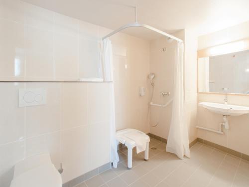 巴黎B&B HOTEL Paris Porte des Lilas的带淋浴和盥洗盆的白色浴室