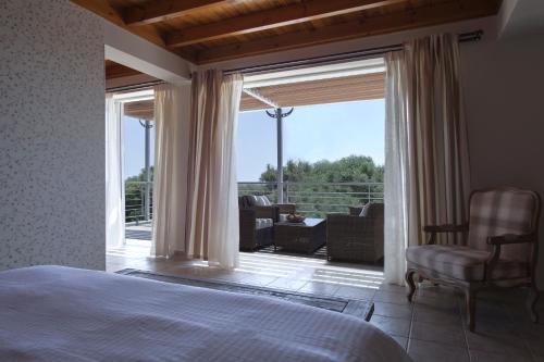 马拉松波利斯Dialiskari Villas的一间卧室设有一张床和一个滑动玻璃门