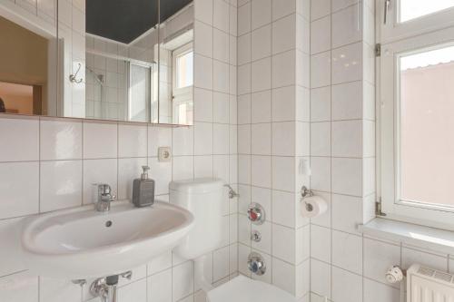 诺伊鲁平Altstadt Ferienwohnung的白色的浴室设有水槽和镜子