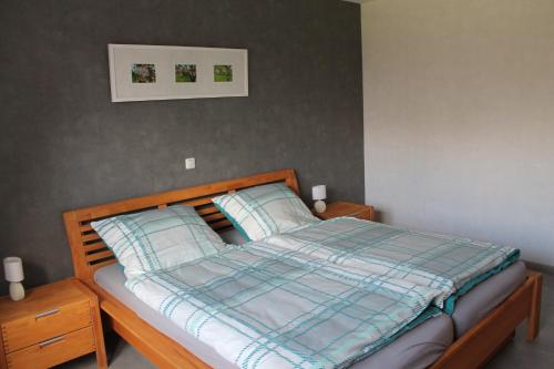 许特根瓦尔德Hardthof - Hürtgenwald的一张带蓝色铺面毯子和两个枕头的床