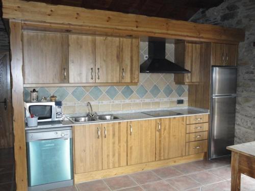 克拉尔夫斯La Cabanya de Cal Forn de Serrat的厨房配有木制橱柜、水槽和微波炉