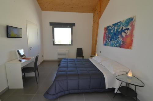 阿尔塔穆拉Masseria La Meridiana的一间卧室配有蓝色的床和一张书桌