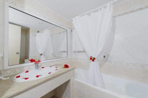 莫纳斯提尔Hotel El Habib Monastir的一间带水槽、浴缸和镜子的浴室