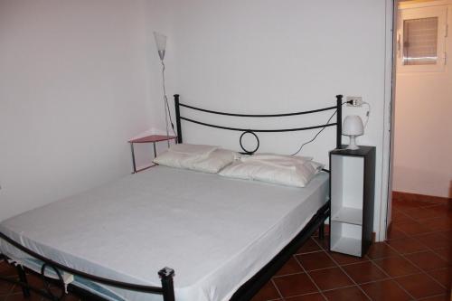 冯塔尼比安奇La Piccola Musa的一张带白色床单和黑色床头板的床