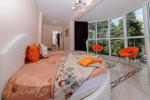 桑丹斯基Sandanski Peak Guest Rooms的一间卧室配有一张带橙色椅子的大床