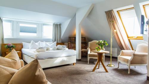 蒂门多弗施特兰德Hotel Holsteiner Hof GmbH的卧室配有一张床和一张桌子及椅子