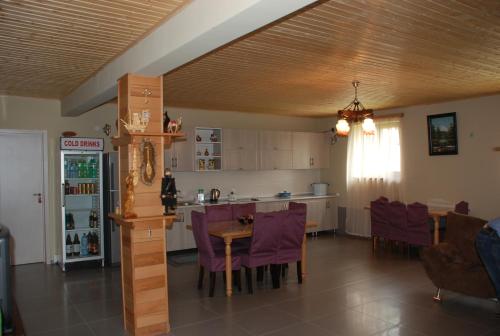 梅斯蒂亚Guest House Lasili的厨房以及带桌子和紫色椅子的用餐室