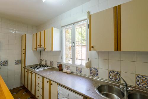 托雷斯卡萨约里纳乡村民宿的厨房配有黄色橱柜、水槽和窗户。