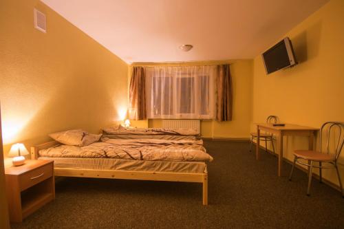 利耶帕亚The Bunker hostel的一间卧室配有一张床、一张桌子和一个窗户。