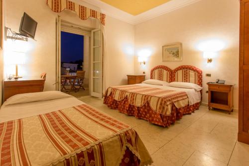 奥里斯塔诺马里亚诺IV皇宫酒店的酒店客房设有两张床和一个阳台。