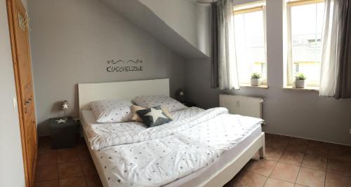 格洛韦Ferienwohnung Möwe的一间卧室配有带白色床单和枕头的床。