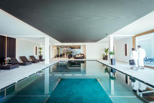 圣瓦伦蒂诺阿拉穆塔瓦尔德康尼琴别墅酒店的一座游泳池,里面的人站在那儿