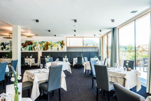 圣瓦伦蒂诺阿拉穆塔瓦尔德康尼琴别墅酒店的餐厅设有白色的桌椅和窗户。