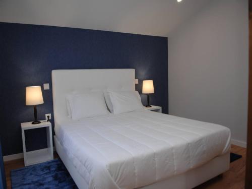 菲盖拉-达福什海滨迷人旅馆的一间卧室配有一张带两盏灯的大型白色床。