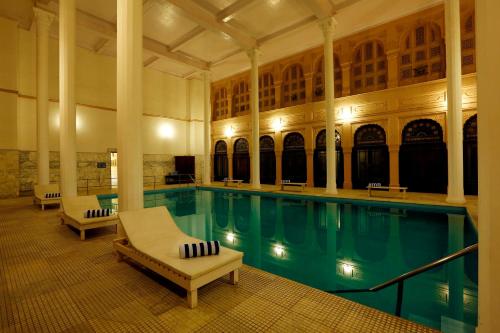 比卡内尔拉里贾遗产宫殿酒店的一座带两把躺椅的游泳池以及一座大型建筑