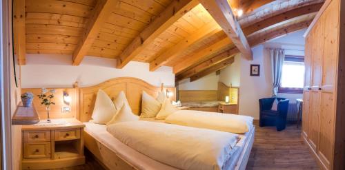 圣克里斯蒂娜Apartment Suliva的一间带两张床的卧室,位于木天花板的房间