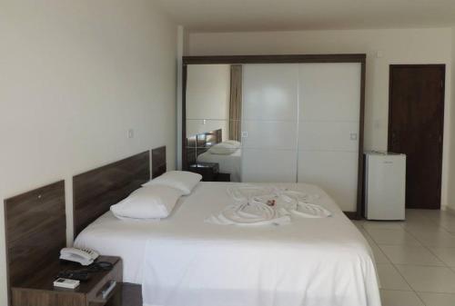 萨利纳斯-达马加里达Salinas Praia Hotel的卧室配有一张白色大床和镜子