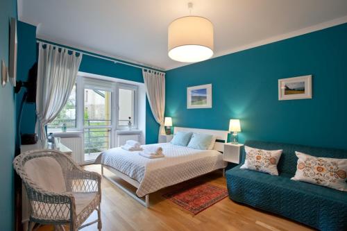 克雷尼察Trzy Siostry的蓝色的卧室配有床和沙发