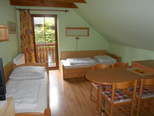 泽勒兹纳·鲁达Apartmány Base Camp的一间设有两张床和一张桌子及椅子的房间