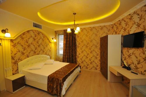 巴统伊比利亚酒店的一间卧室设有一张黄色天花板的床