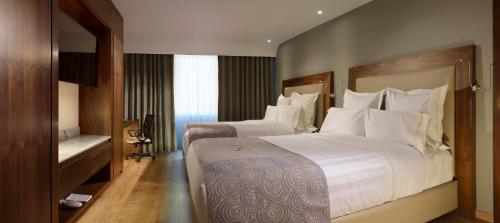 锡劳HS HOTSSON Hotel Silao的酒店的客房 - 带2张带白色枕头的床