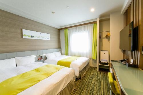 东京上野萨东尼酒店的酒店客房设有两张床和电视。