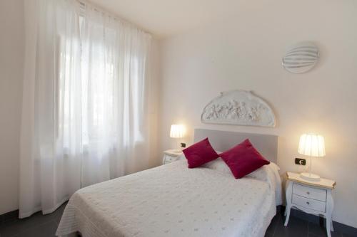 佛罗伦萨坎托戴米勒旅馆的卧室配有白色床和2个红色枕头