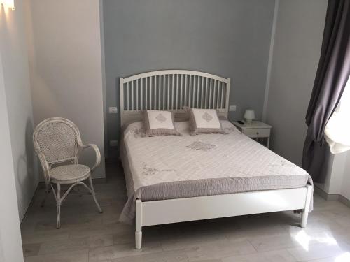 拉齐塞Camere La Forgia的卧室配有白色的床和椅子