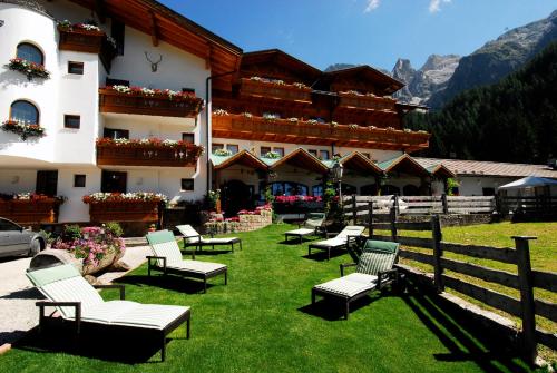 圣马蒂诺-迪卡斯特罗扎Hotel Stalon Alpine Chic的前面草上带椅子的建筑
