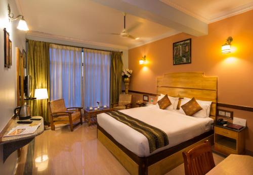 德瓦纳哈利-班加罗尔Hotel Presidency Kempegowda International Airport Bangalore的配有一张床和一张书桌的酒店客房