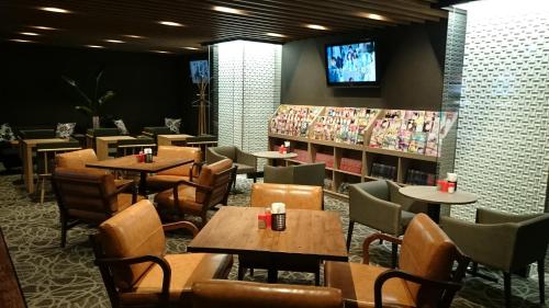横滨伊势佐木町格兰海关胶囊旅馆的一间带桌椅和电视的餐厅