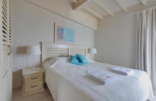 金沙卡巴坤度假公寓的白色卧室配有白色大床和蓝色枕头