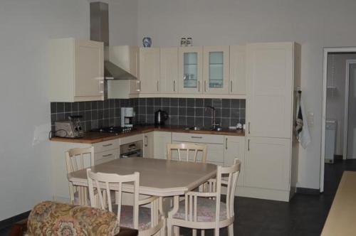 OdiliapeelVino Grando Cottage的厨房配有白色橱柜和桌椅