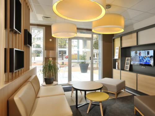 卡威尔奎B&B HOTEL Lyon Caluire Cité Internationale的客厅配有沙发和桌子