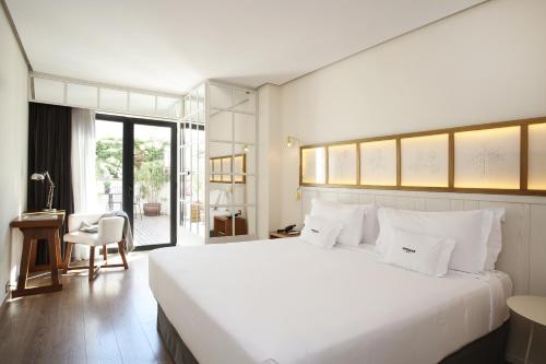 巴塞罗那Ofelias Hotel 4Sup by Bondia Hotel Group的卧室配有一张白色大床和一张书桌
