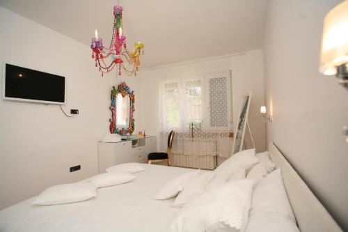 特罗吉尔Domus Apartments的白色卧室配有一张床和一个吊灯