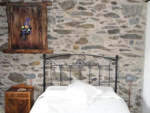 克拉尔夫斯La Cabanya de Cal Forn de Serrat的一间卧室设有一张床和石墙