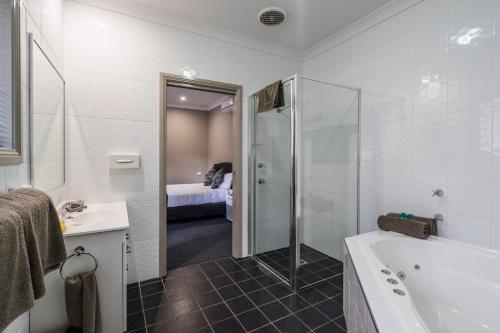 达博阿库纳汽车旅馆和公寓的带淋浴、浴缸和盥洗盆的浴室