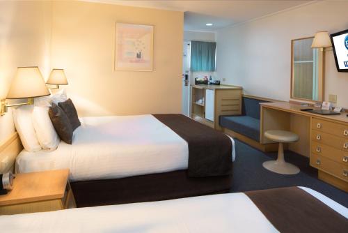 杰拉尔顿Hospitality Geraldton SureStay Collection by Best Western的酒店客房配有两张床和一张书桌